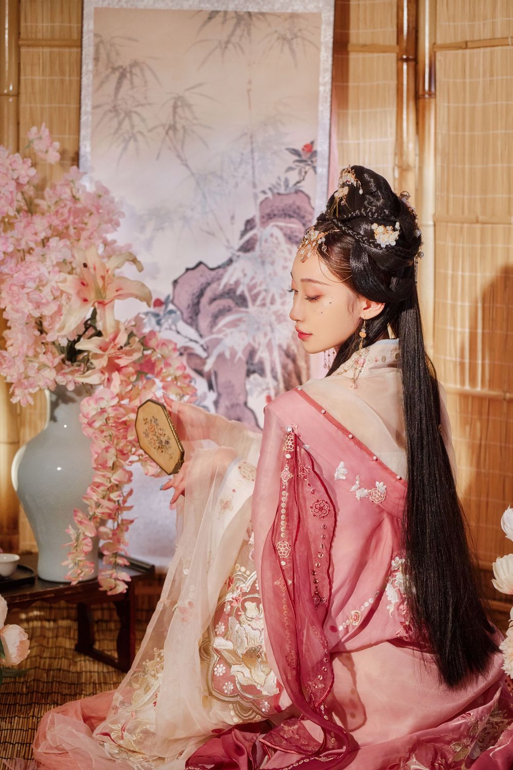 Glamorous pink Hanfu portrait featuring an amazing style, cold gaze, and light bamboo backdrop, captured by Imagine Image Studio.