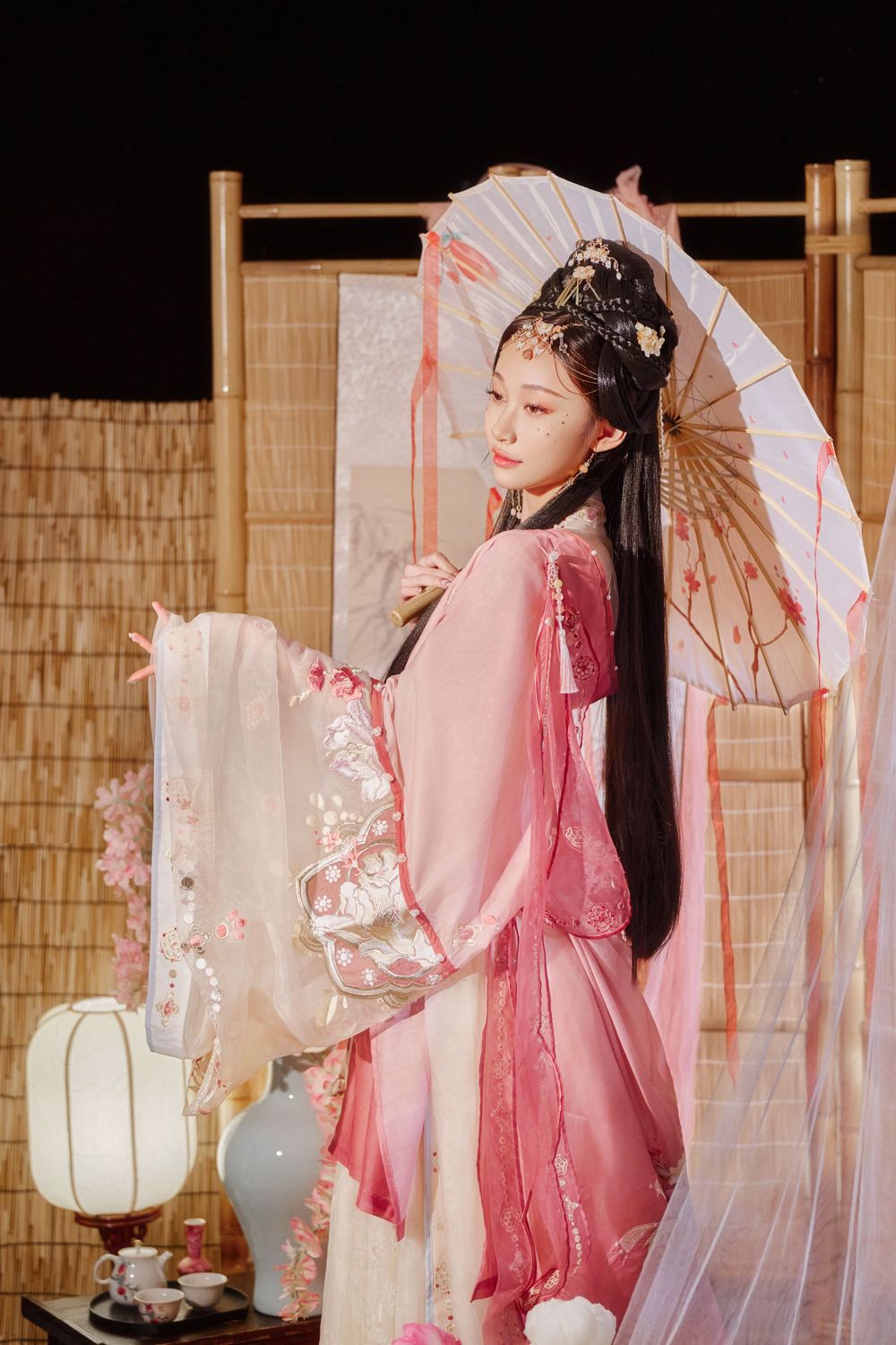 solo portrait in a gorgeous pink Han-element dress with a cold gaze against a light bamboo mat, by Imagine Image Studio.