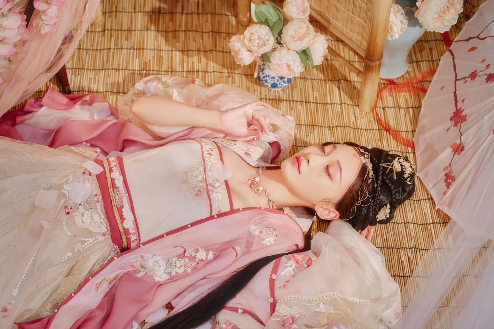 solo portrait in a gorgeous pink Han-element dress with a cold gaze against a light bamboo mat, by Imagine Image Studio.