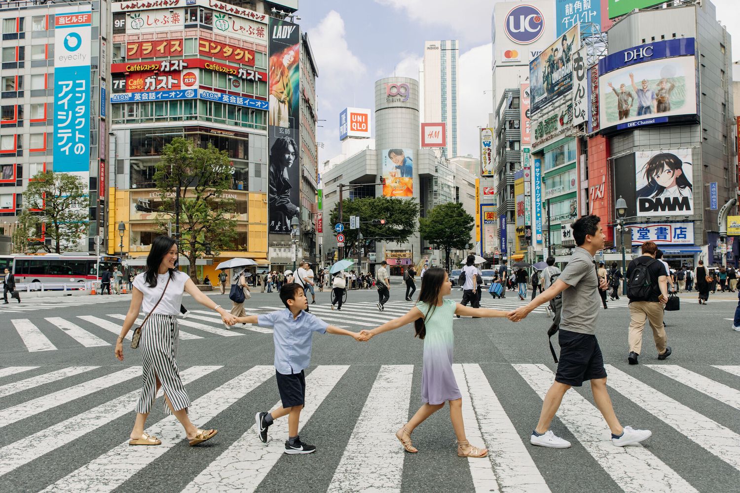 People strike poses while crossing the famous Shibuya crossing in Tokyo, Japan.