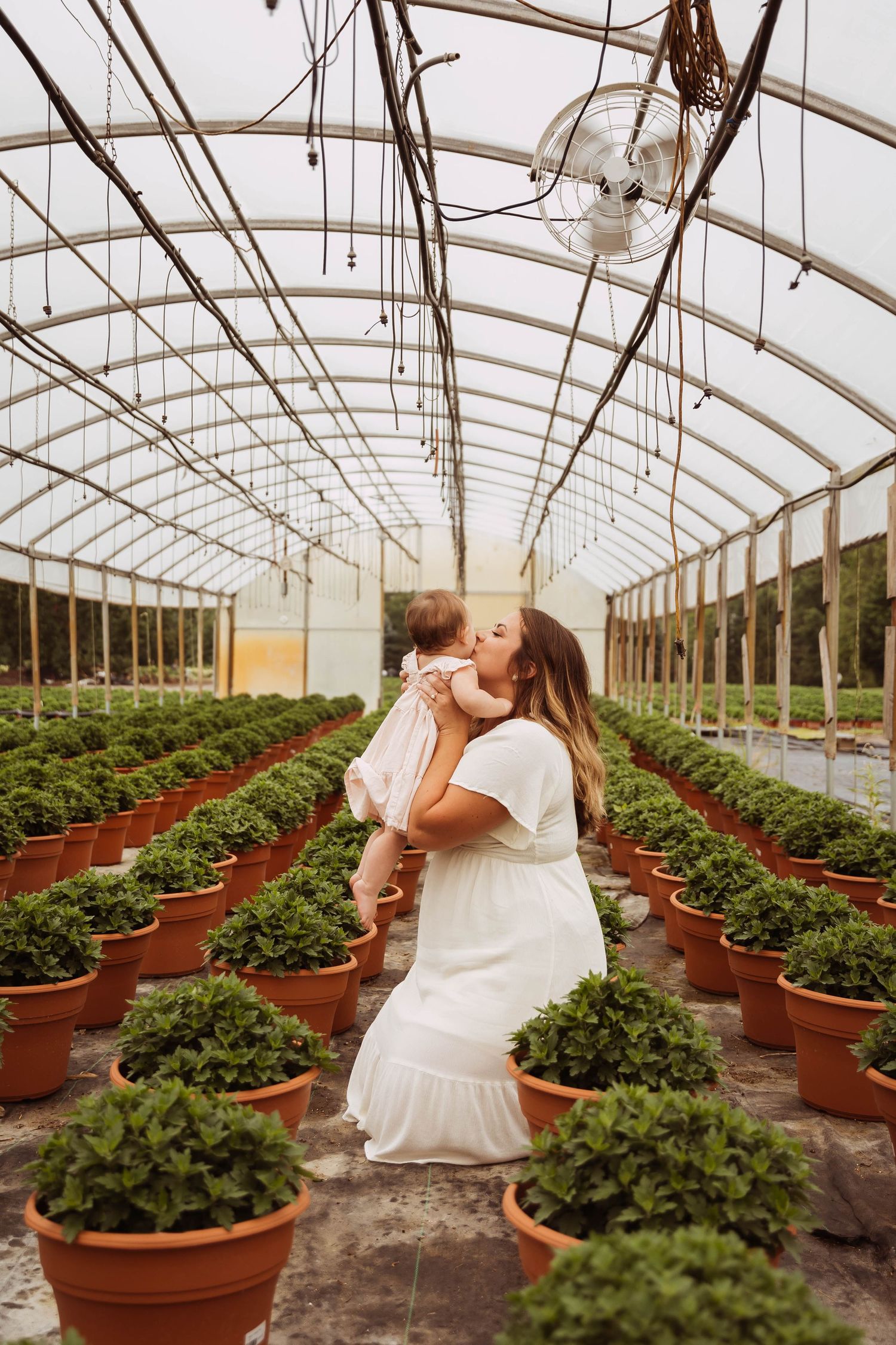 Candid family portrait in greenhouse taken by Elle & Co. Photography in Southeast Michigan