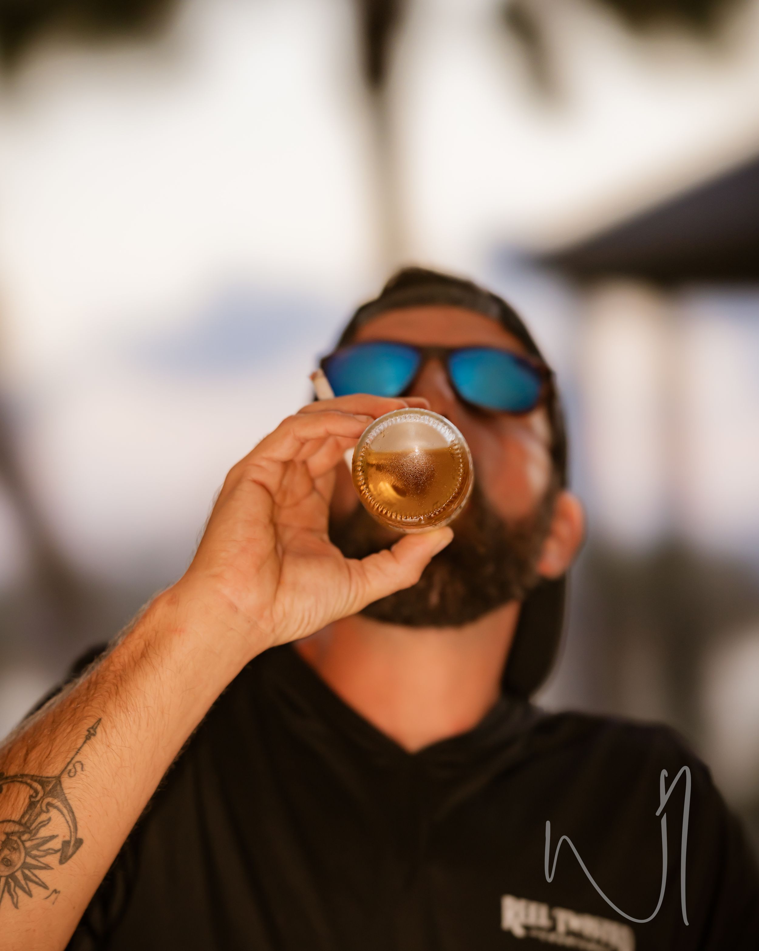 A person in sunglasses takes a sip from a small glass in a sequence of four similar shots.