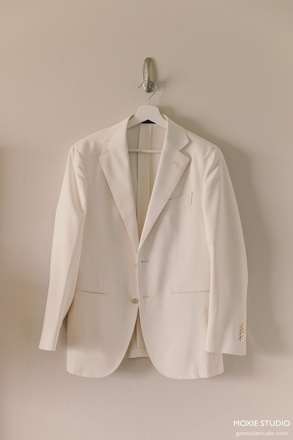 White formal blazer jacket displayed in multiple angles against a neutral wall background.