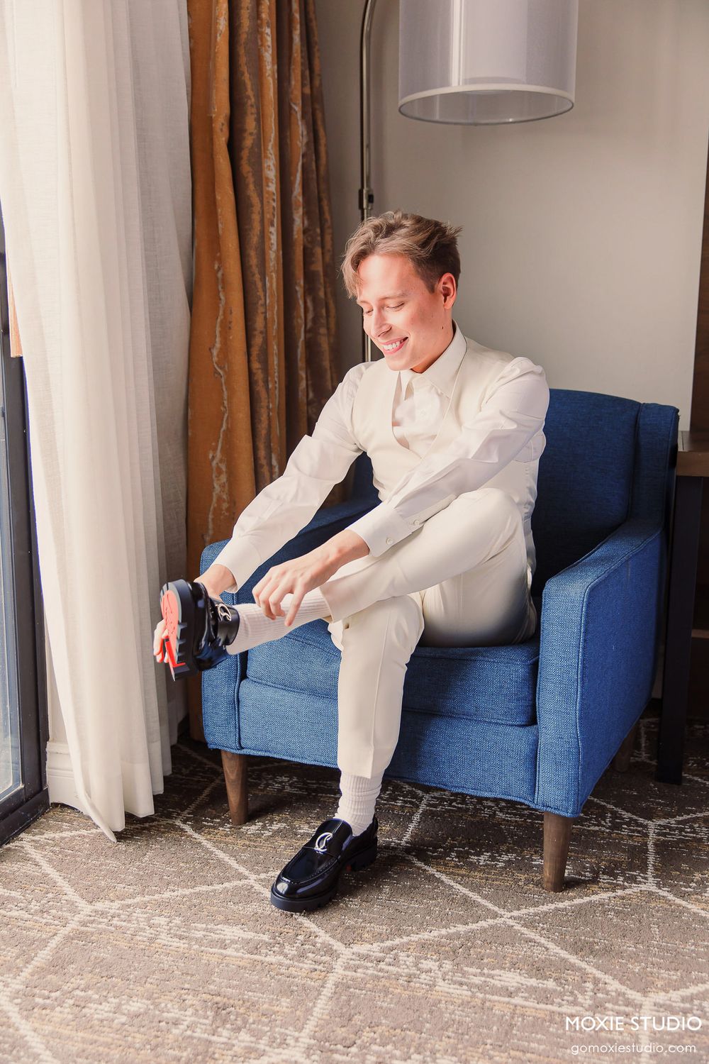 A sequence of photos showing someone in white attire sitting in a blue armchair while putting on dress shoes.