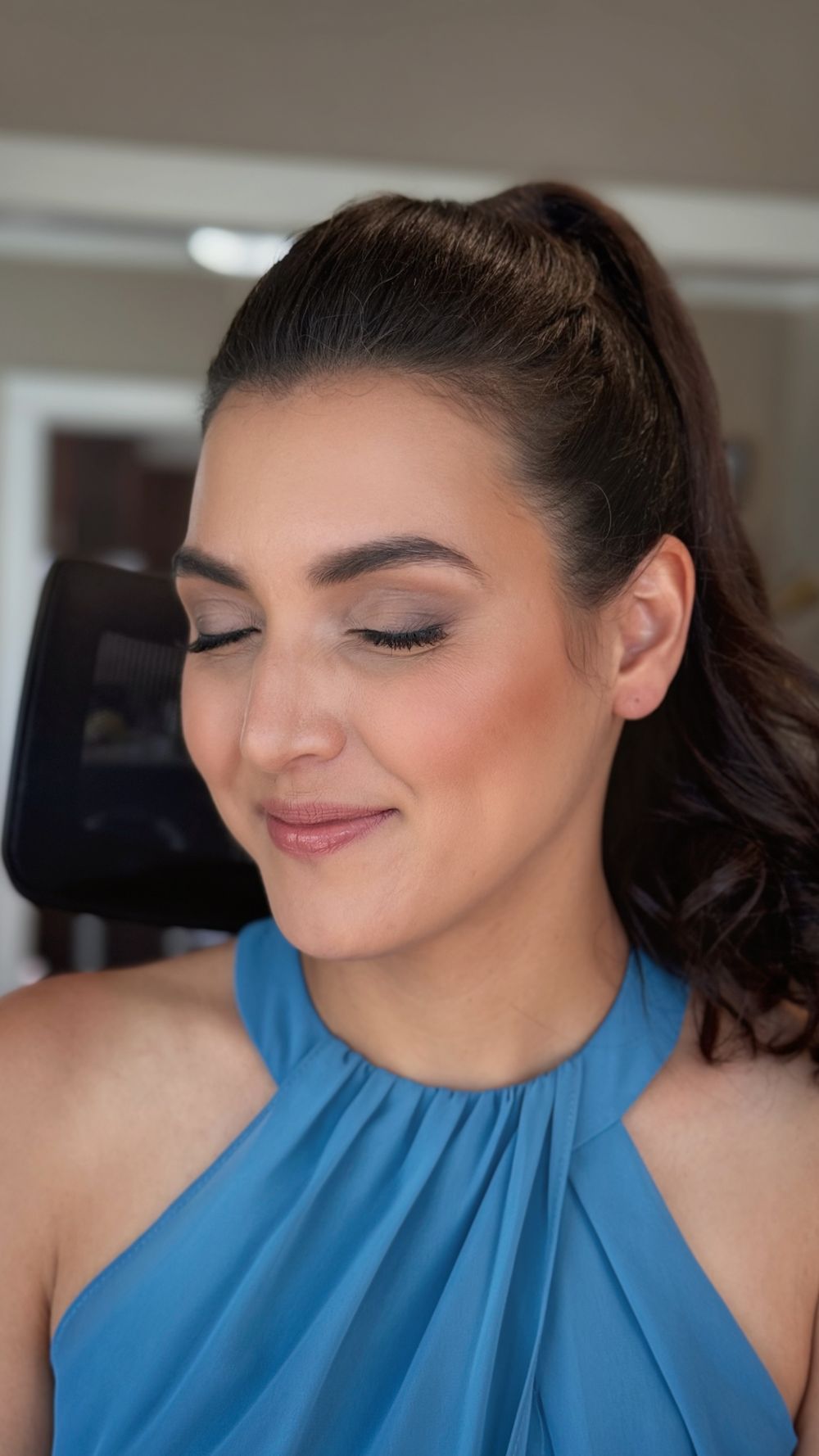 Close-up beauty shots showing professional makeup and a blue halter neckline.