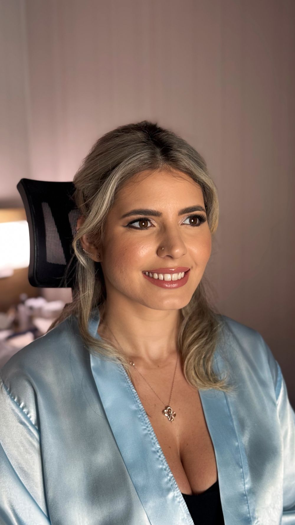 Getting ready photos in a light blue satin robe with professional hair and makeup.