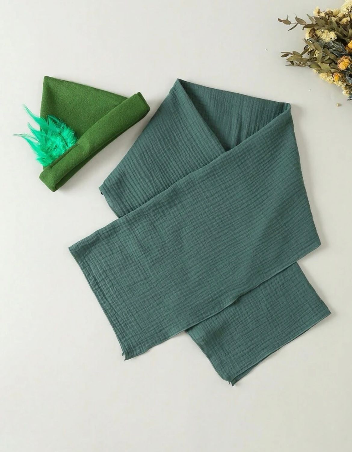 Folded teal green muslin cloth or garment displayed in sequence showing different angles and folds.