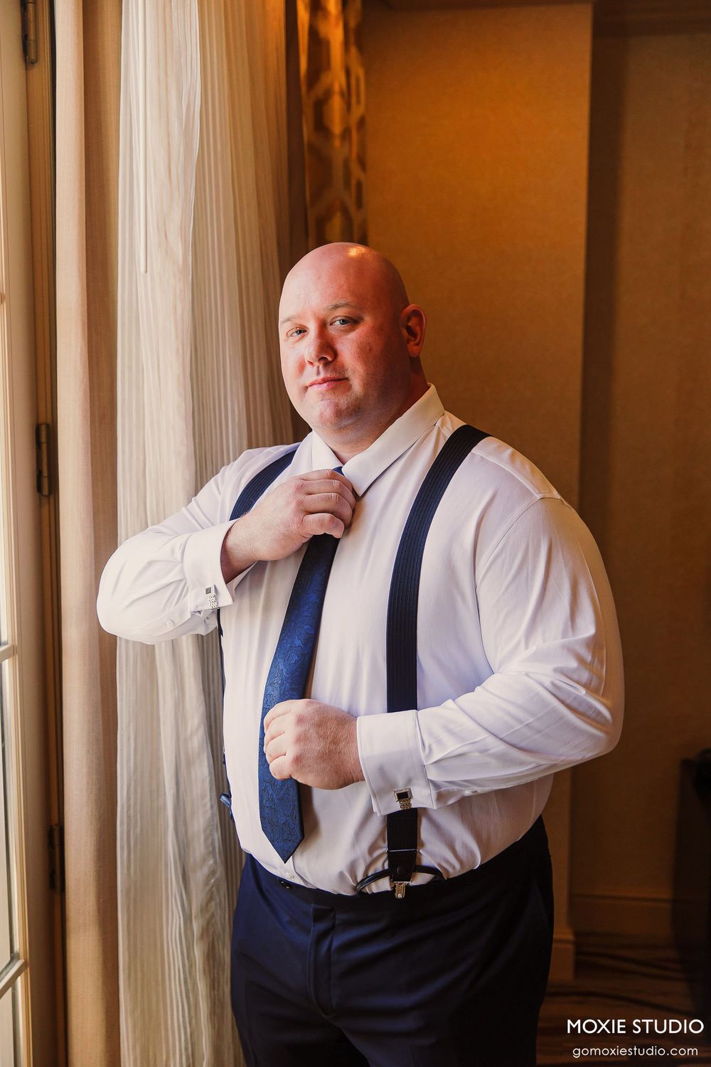 A sequence of photos showing someone adjusting their navy suspenders while wearing a white dress shirt.