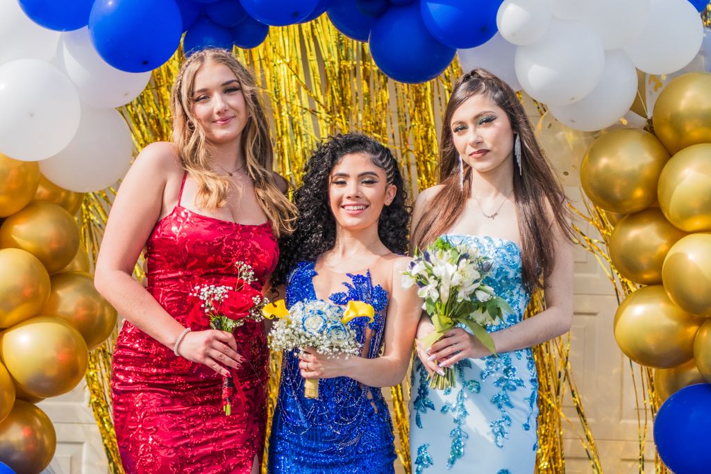 Festive party setup with blue, white, and gold balloons against a metallic backdrop.