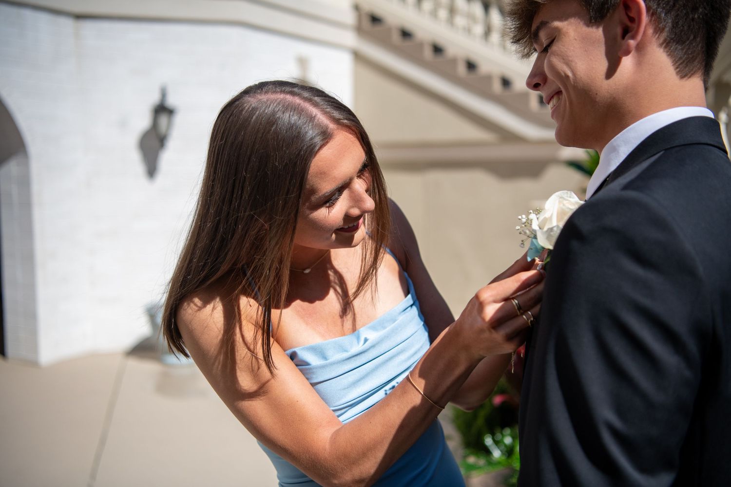 Intimate wedding moments captured against classic white architectural backdrop.
