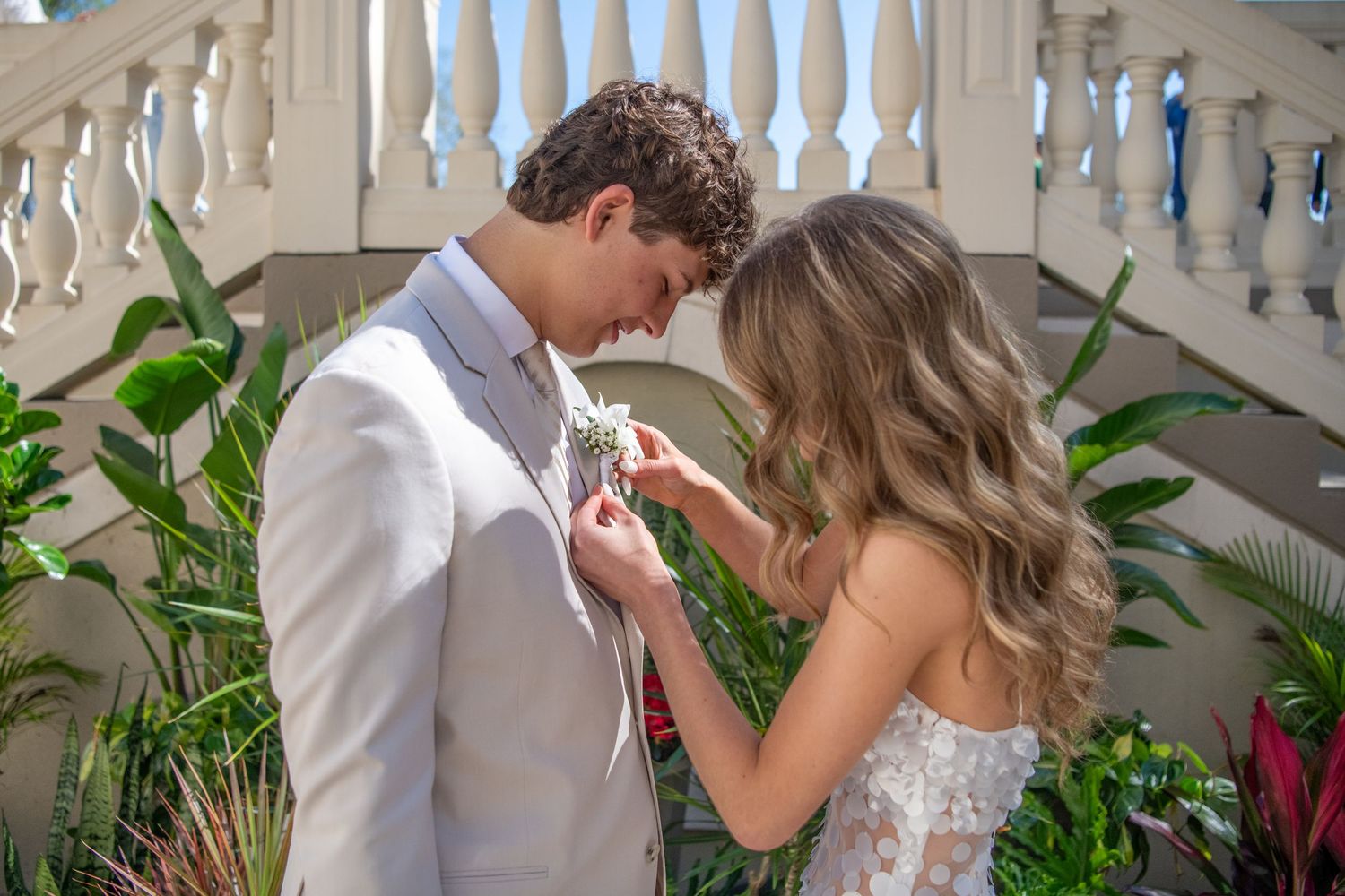 Formal wedding photos being taken against an elegant white balustrade backdrop.