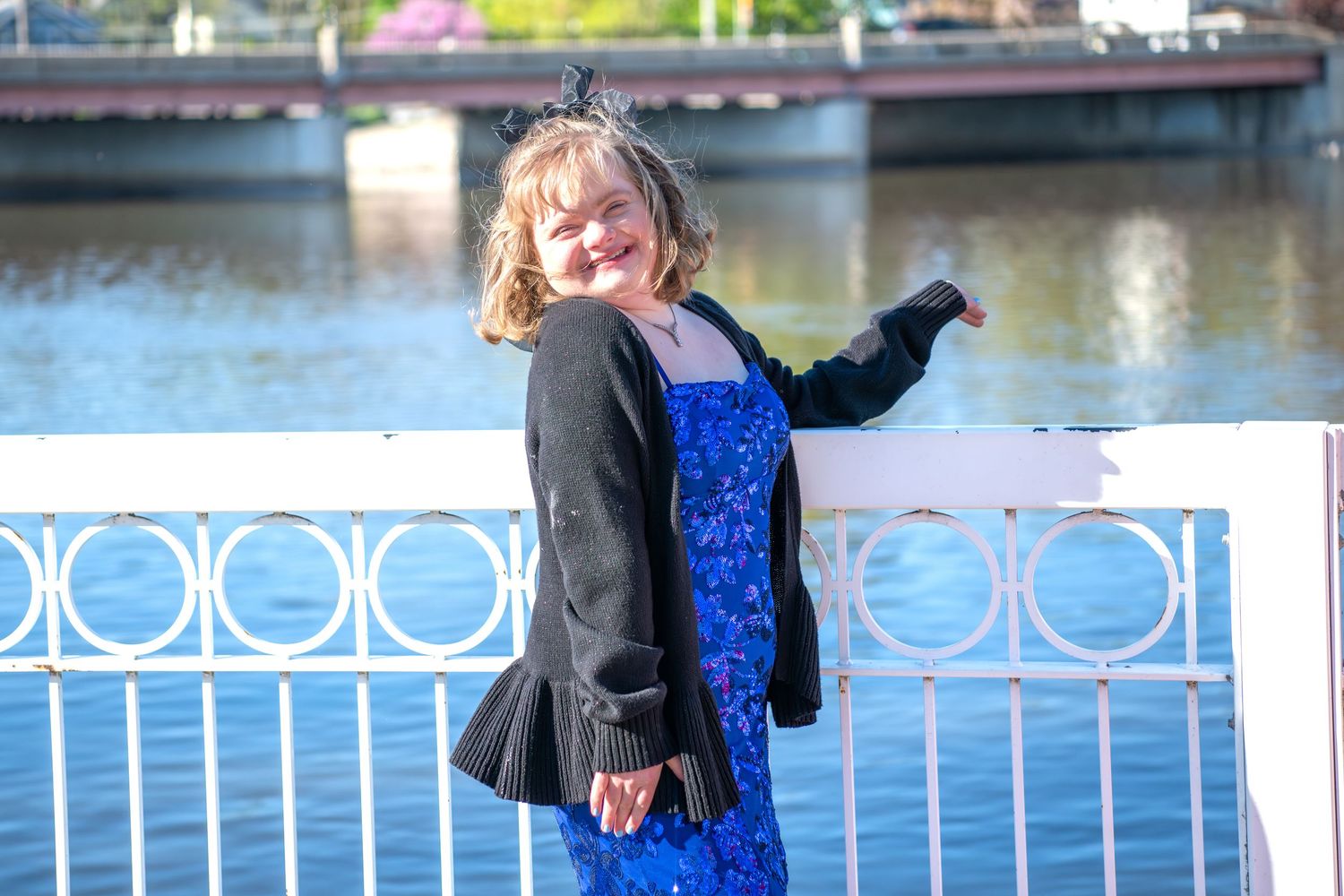 Elegant PROM portraits taken at a waterfront location with ornate white railings and blooming trees in the background.