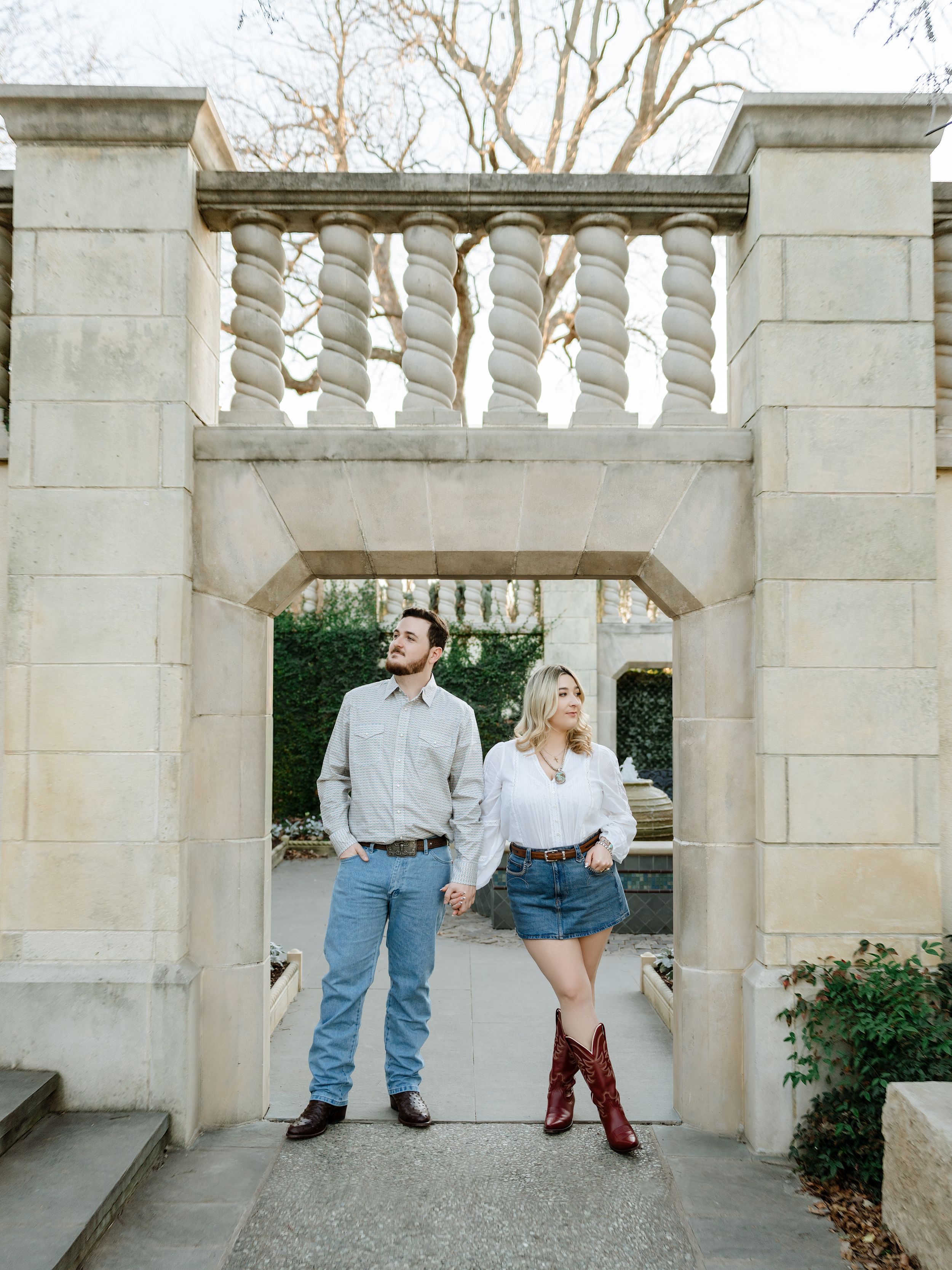 A series of four playful photos showing a couple posing and interacting around white stone columns outdoors.