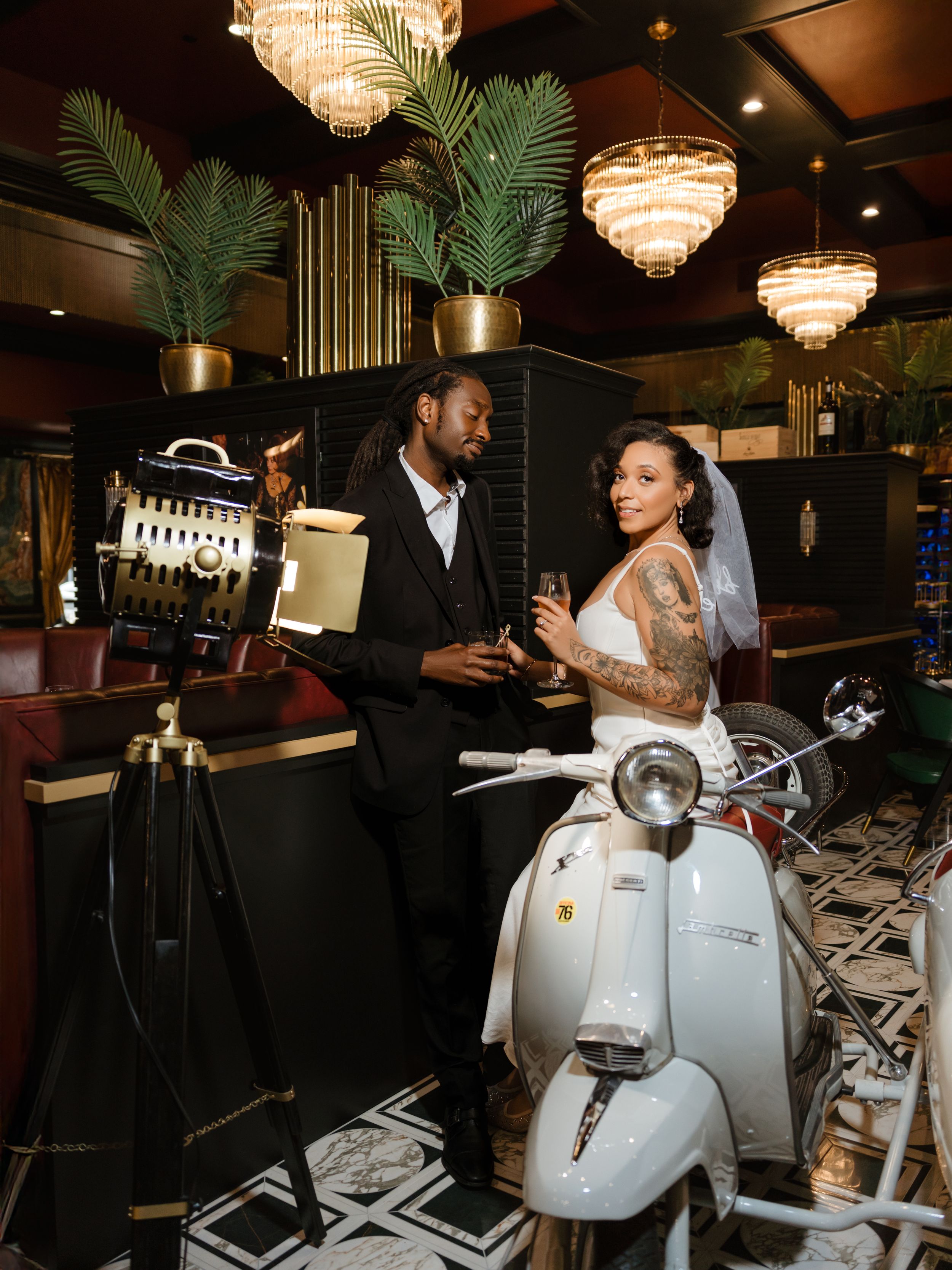A white robot with glowing eyes serves guests at an elegant restaurant with crystal chandeliers and palm decor.