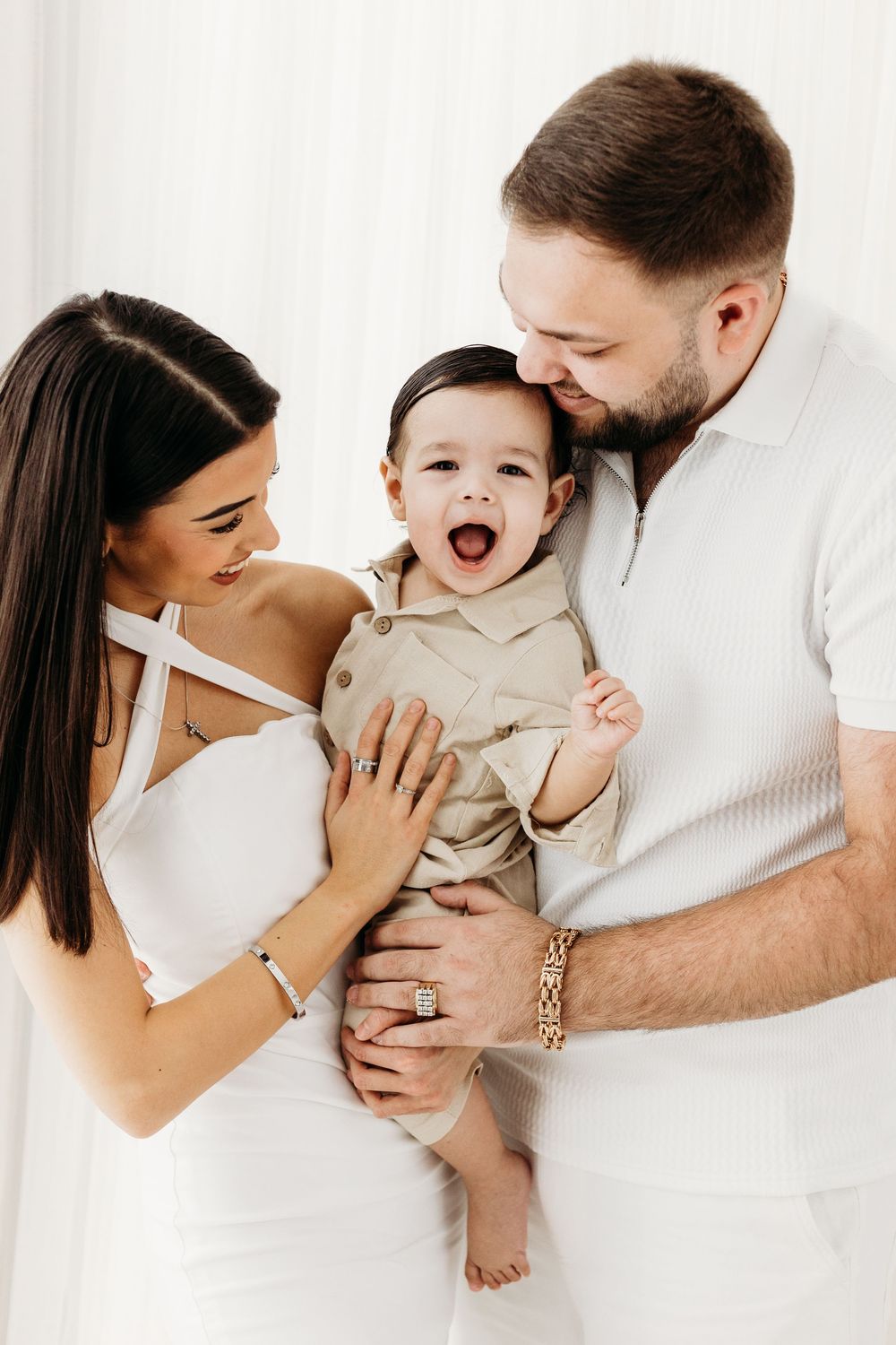 Parents smiling with their young children.