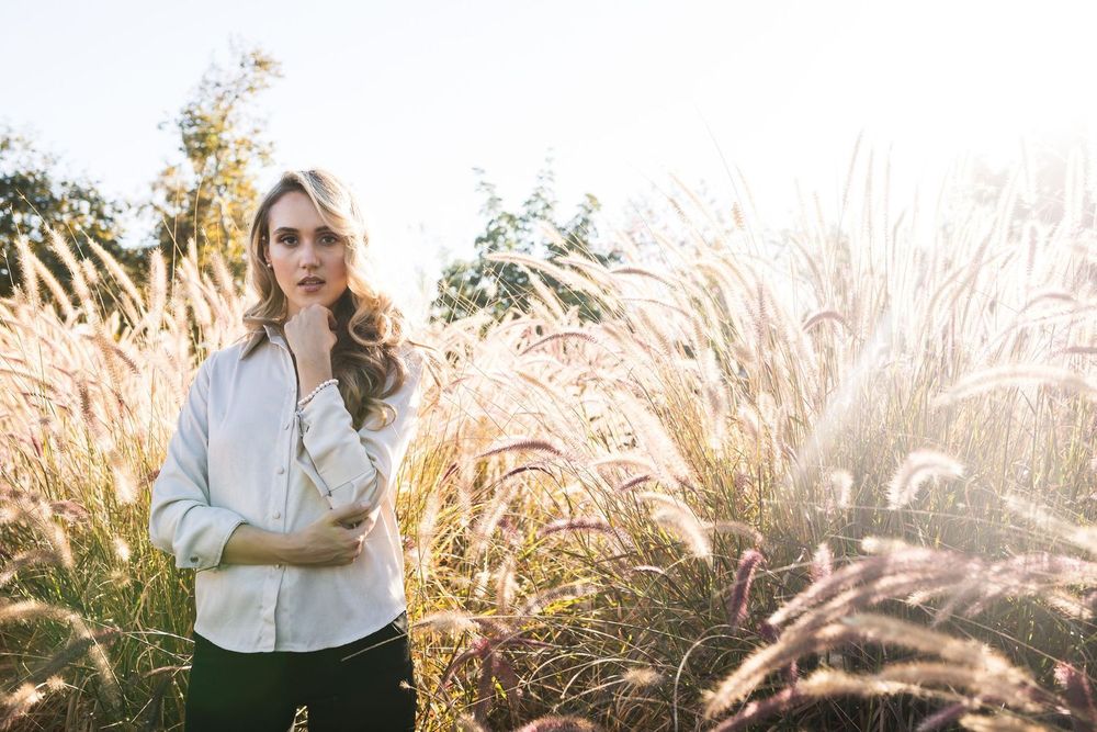A sunset portrait among tall ornamental grasses with golden backlight creating a dreamy atmosphere.