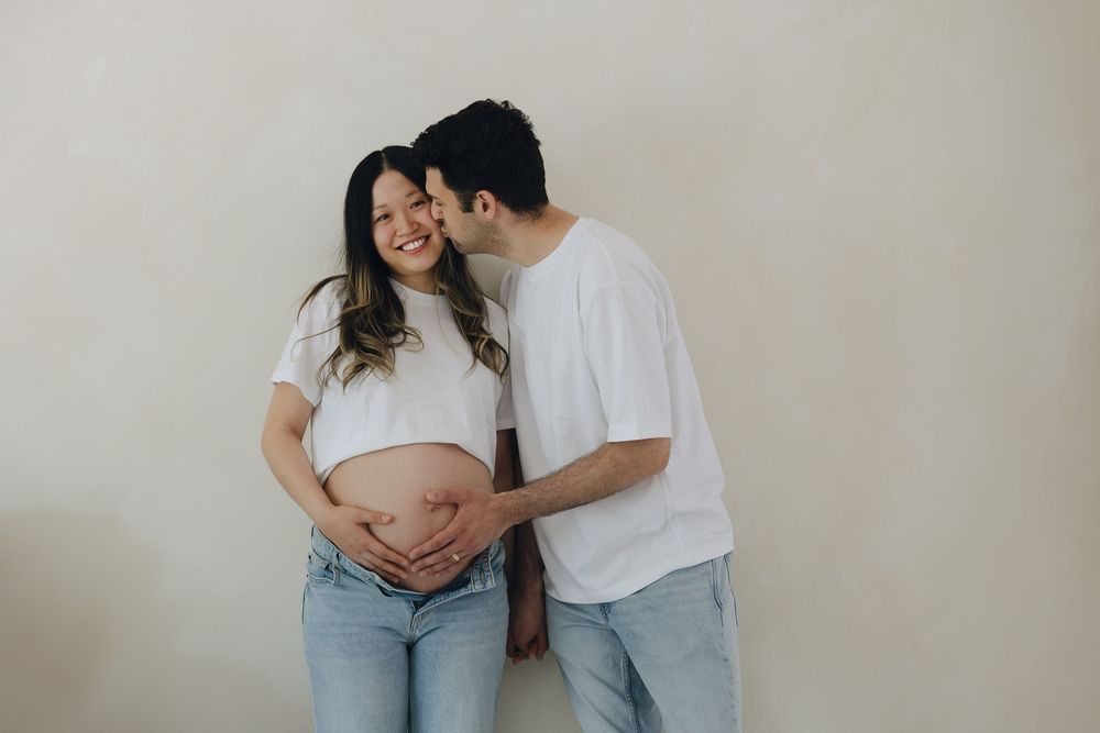 A series of intimate black and white maternity photos showing tender moments between an expectant couple.