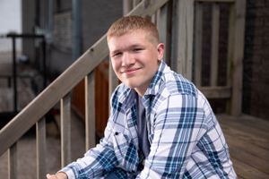 Senior boy pose close while sitting on stairs