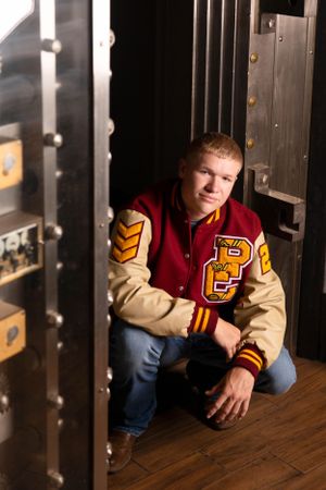 Senior boy pose squatting down from high angle