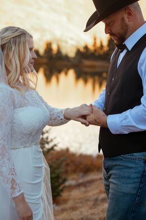 A romantic couple shares intimate moments at sunset by a lake in a series of connected photos.
