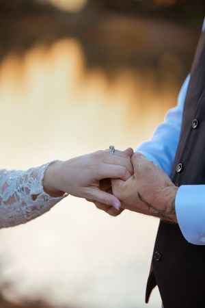 Close-up of hands exchanging rings during a wedding ceremony with soft bokeh background.