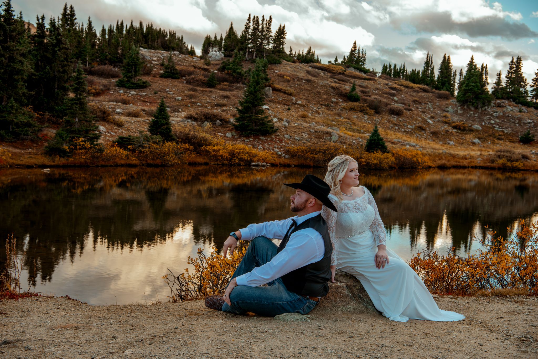 Couple shares intimate moments against stunning mountain lake backdrop during sunset photo session.