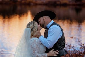 Romantic sunset wedding photos by a tranquil lake with golden hour lighting.