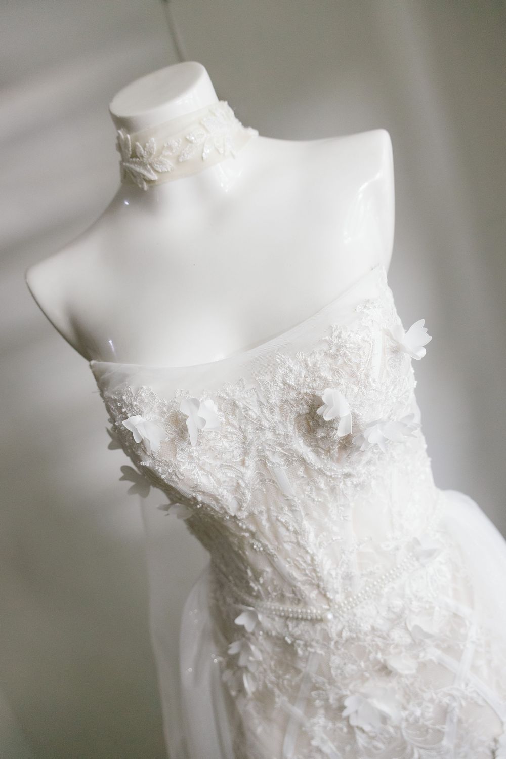 Close-up details of a white wedding dress bodice with delicate lace appliques.