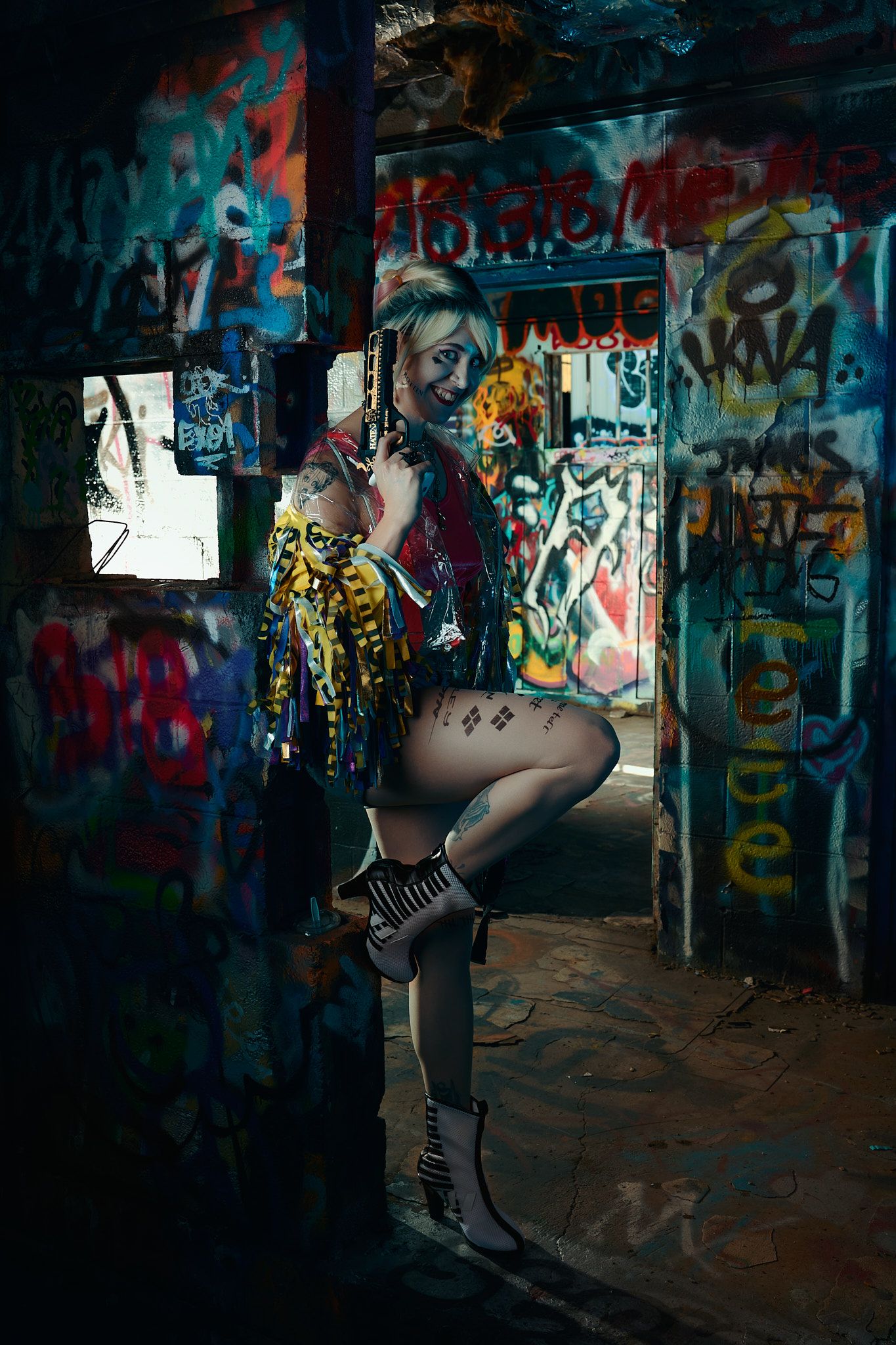 Artistic fashion photo in graffiti-filled urban setting with moody lighting and edgy streetwear styling.