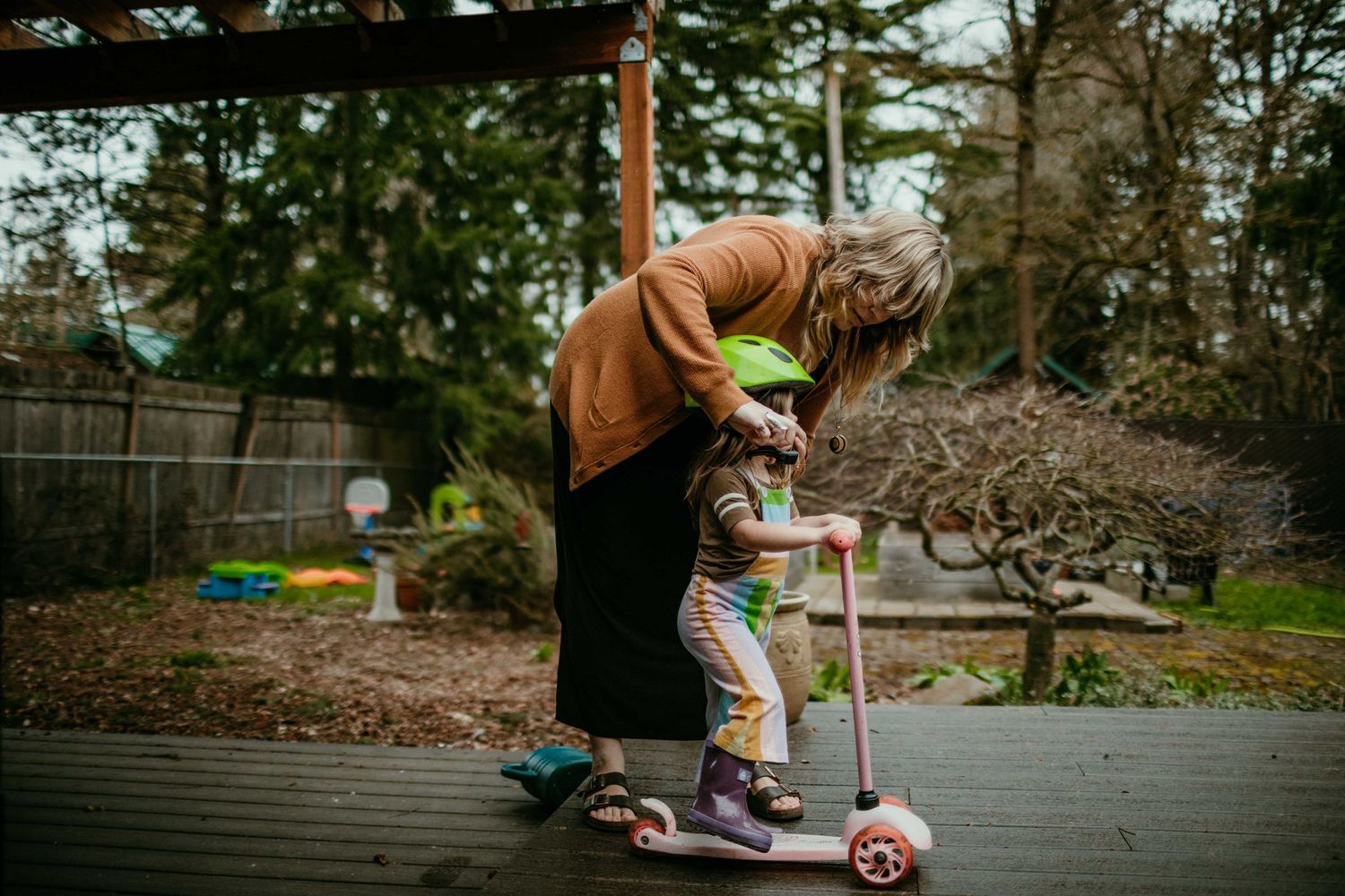 mother helps child put helmet on to play on scooter portland oregon family photography rushes & Waves