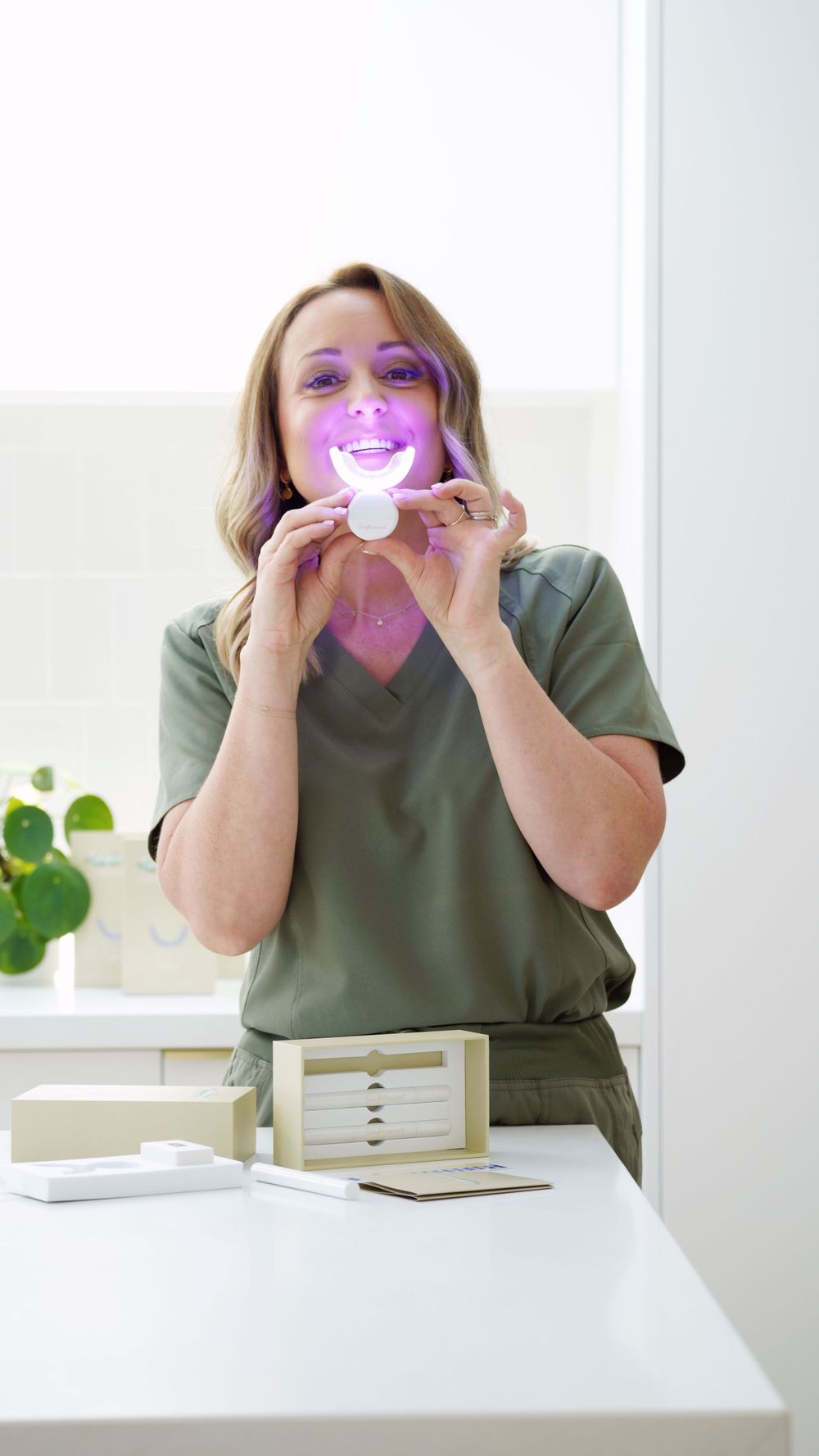 LED teeth whitening treatment demonstration in modern dental office setting.