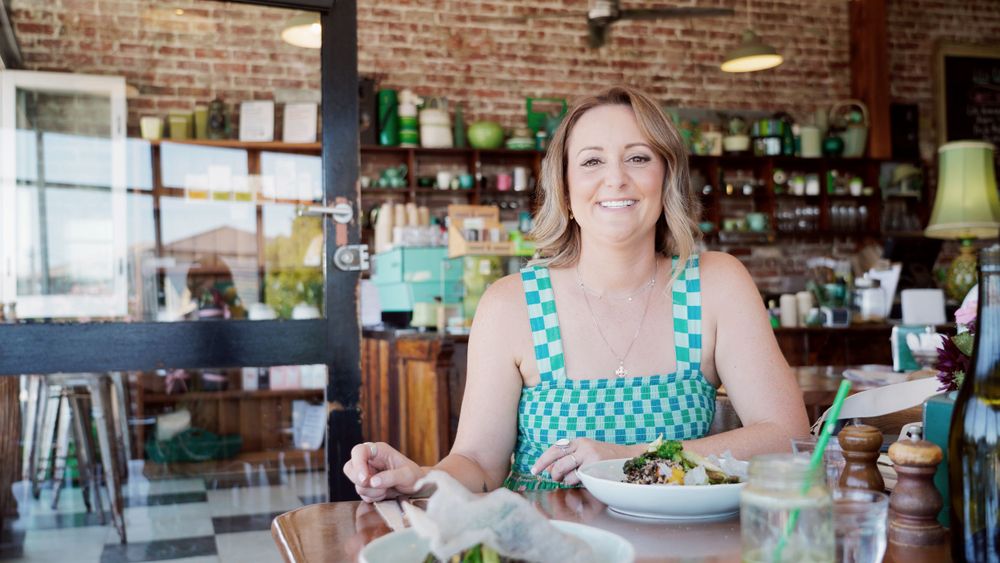 Person dining at rustic restaurant interior with exposed brick walls.