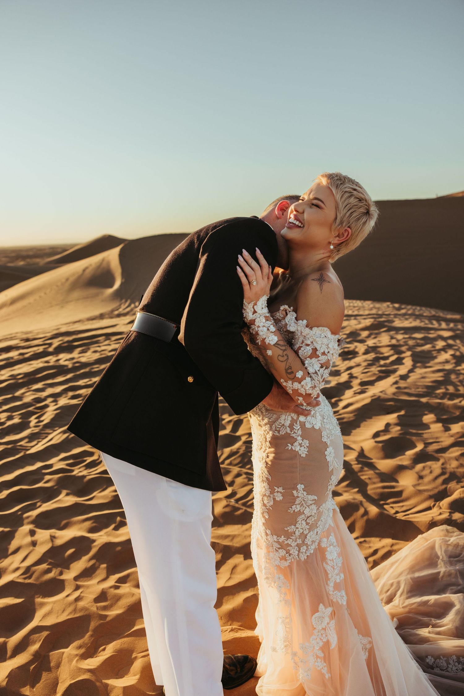 A groom kissing his brides neck at the Imperial Sand Dunes.