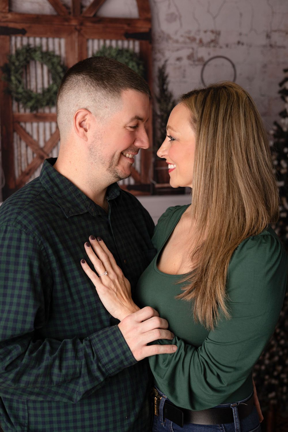 A couple shares intimate laughter together during an indoor photoshoot.