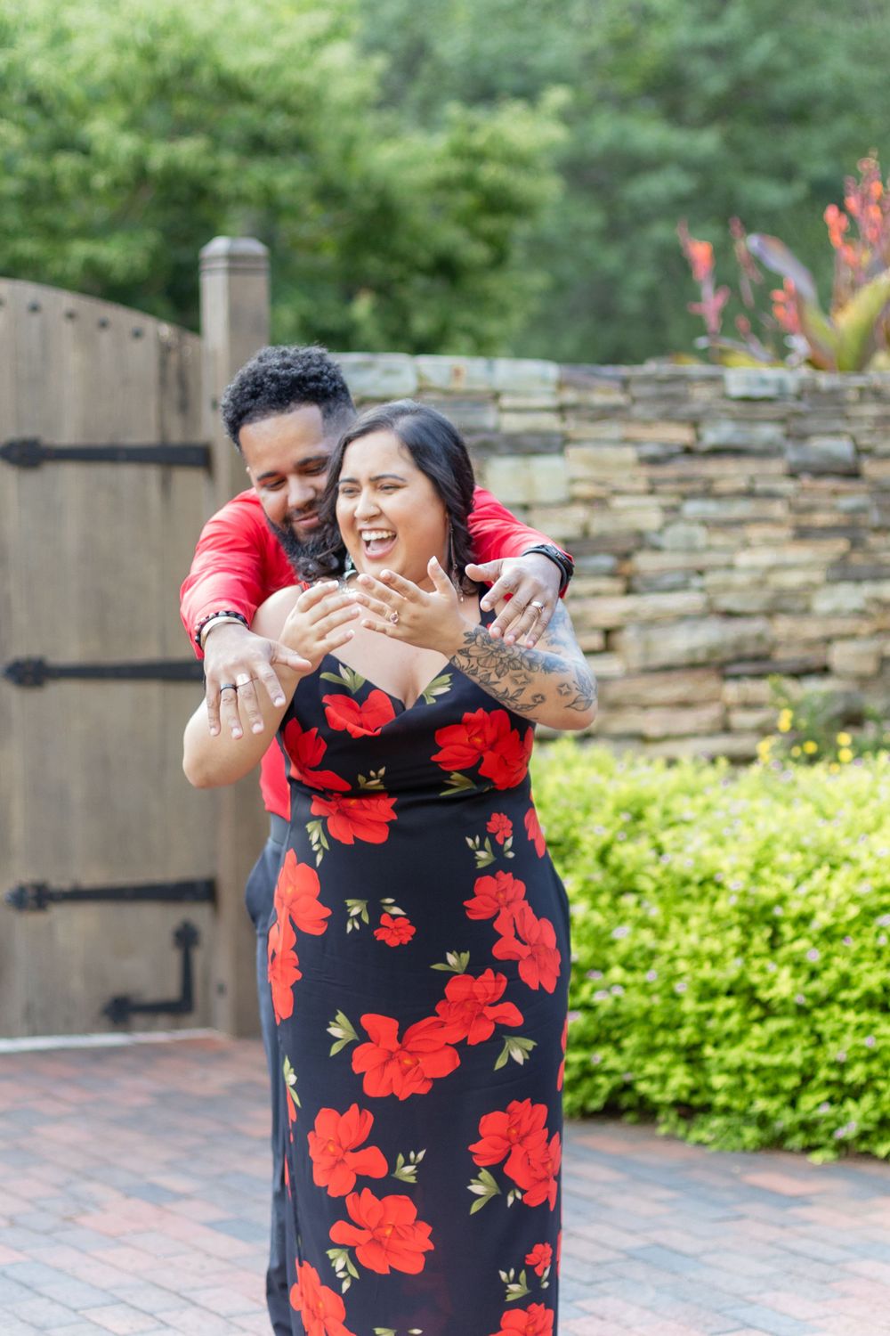 Joyful wedding sequence in a garden featuring a black dress with red floral print.
