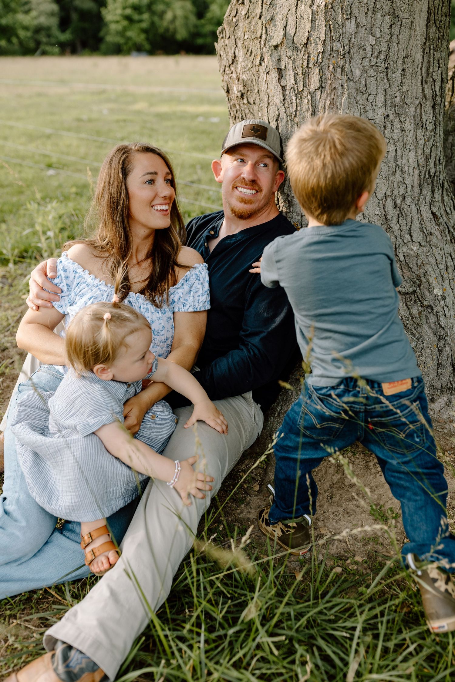 Extended family portrait session in a rustic field setting during golden hour.