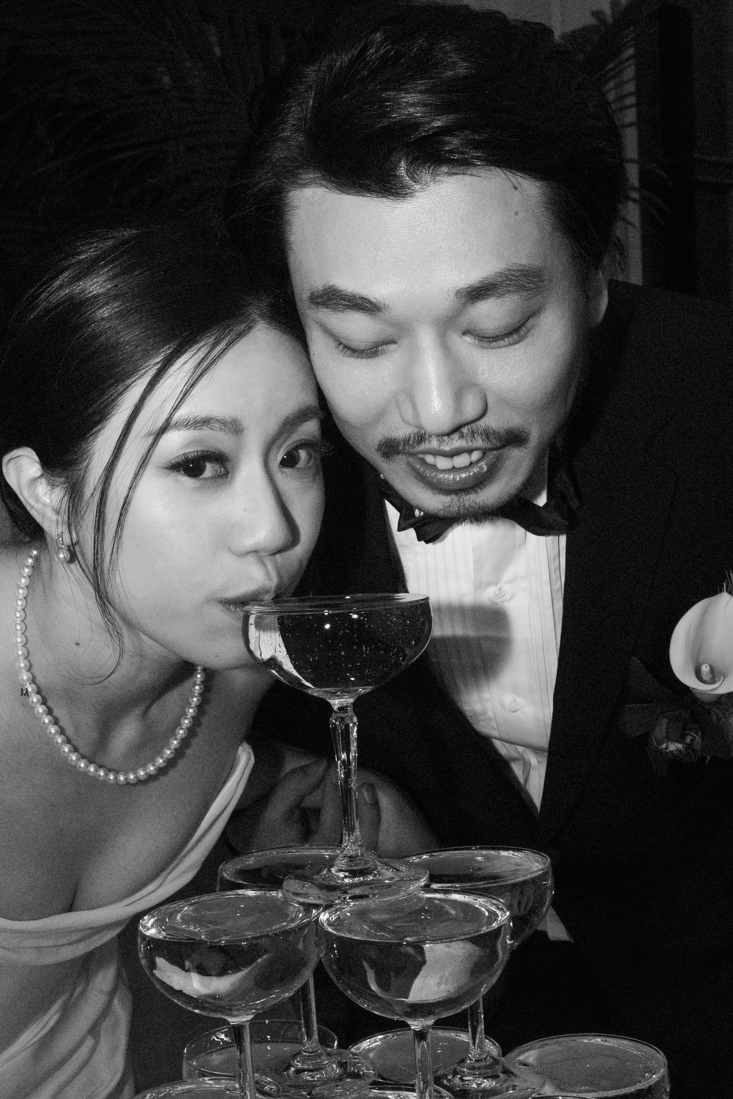An elegant black and white wedding photo showing a couple in formal attire sharing an intimate moment.