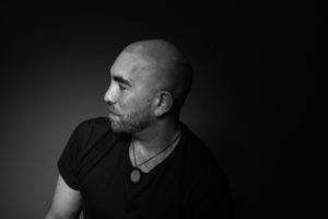 Dramatic black and white profile portrait against dark background.