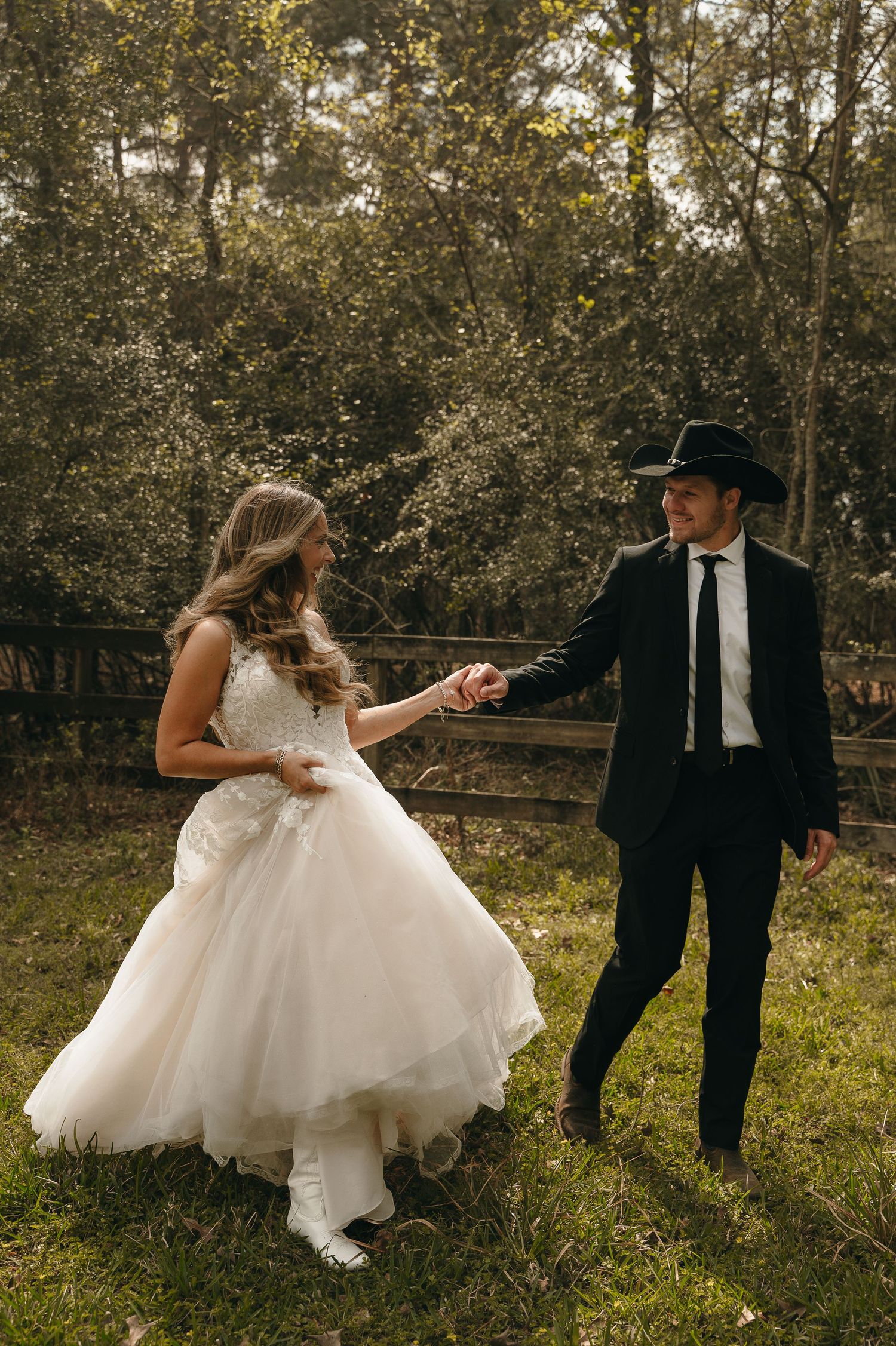 A wedding couple walking along a historic brick building in an urban setting.