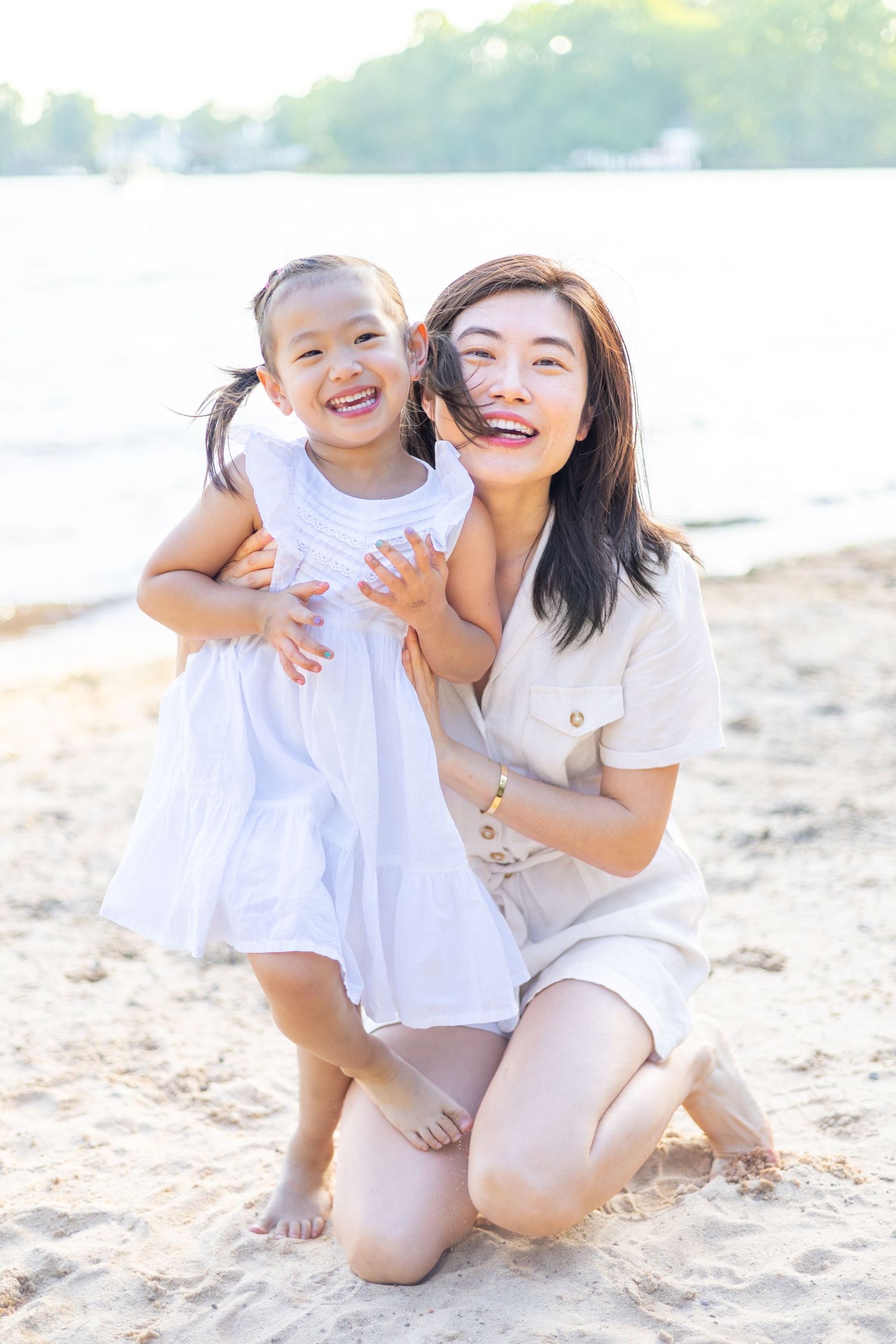 Mom and daughter on the beach laughing