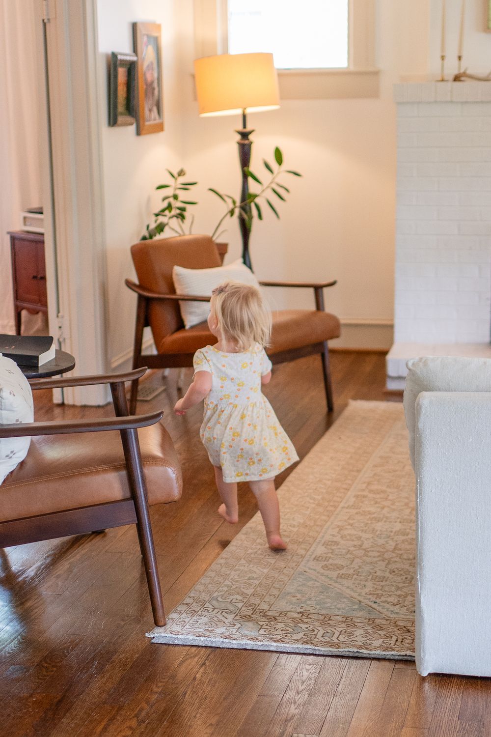 Girl runs through the house joyfully during a fun family session at home.