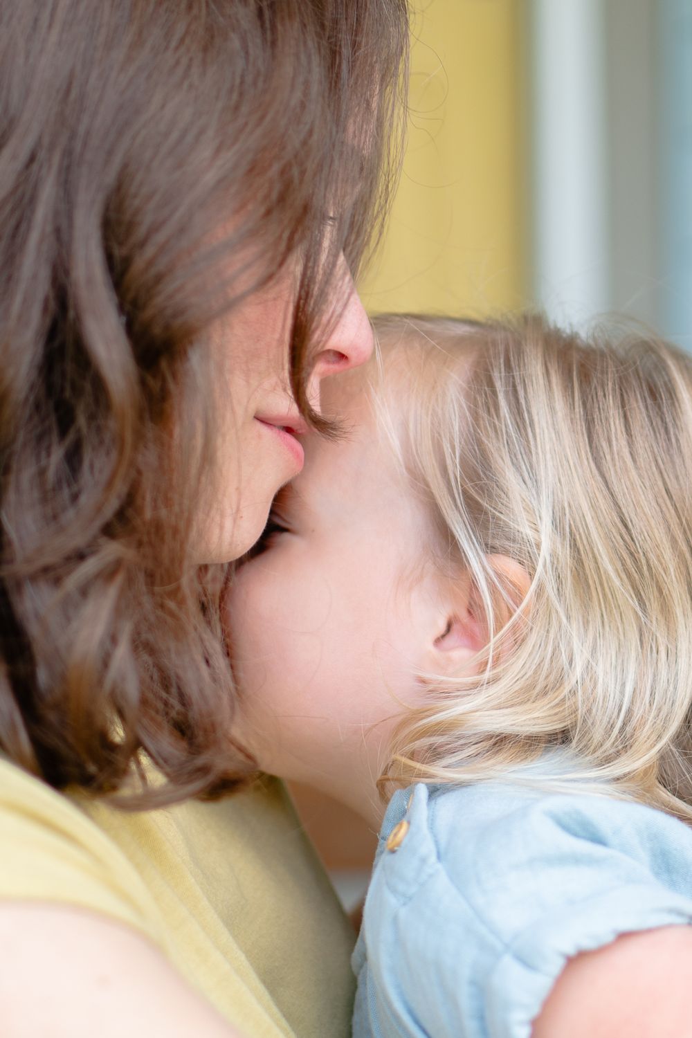 Snuggles with mom and daughter on the front porch during a maternity session in Winston-Salem.