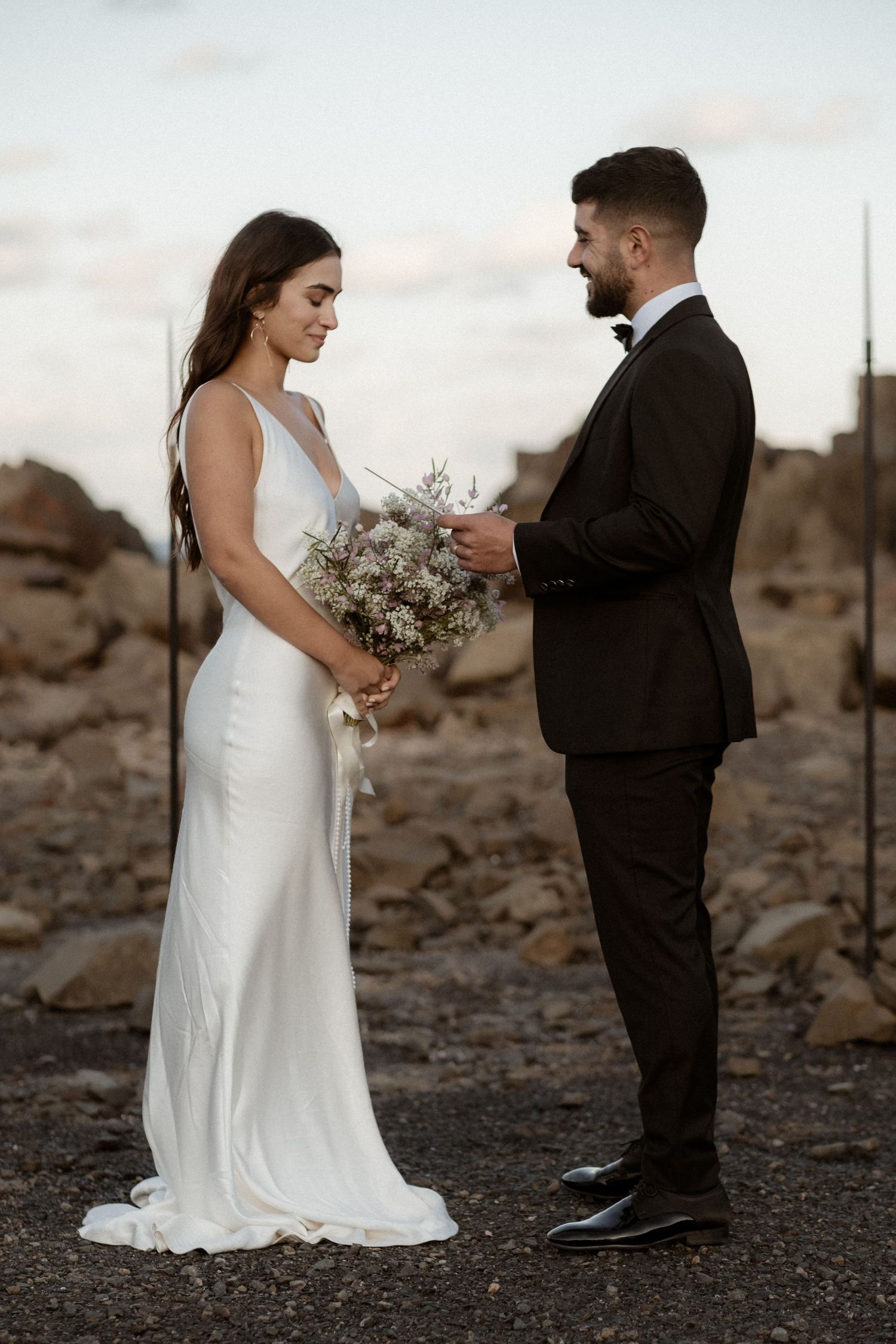 Elegant couple exchanging vows in desert setting with modern minimalist decor.
