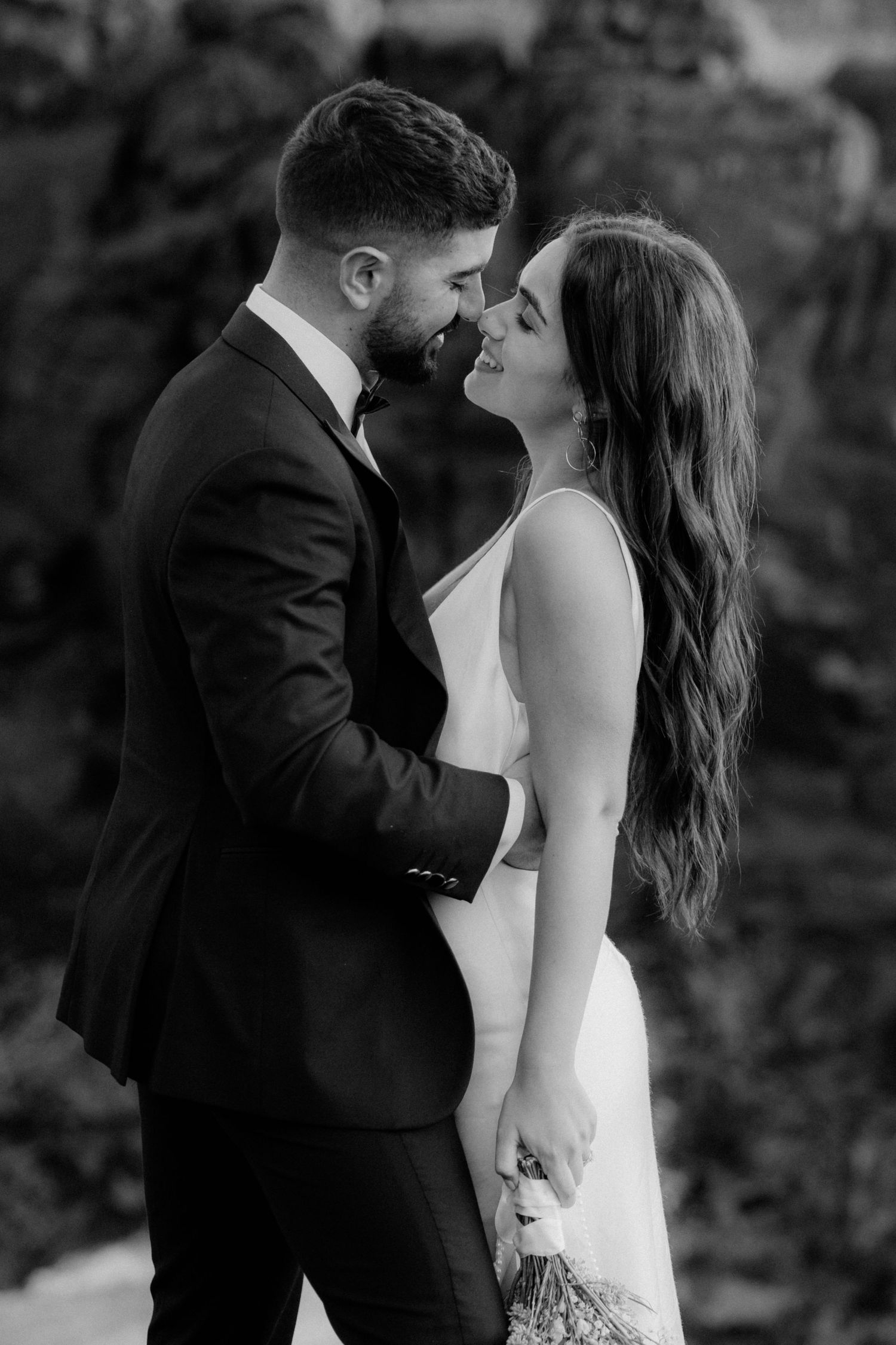 Intimate black and white wedding portrait showing tender moment between couple.