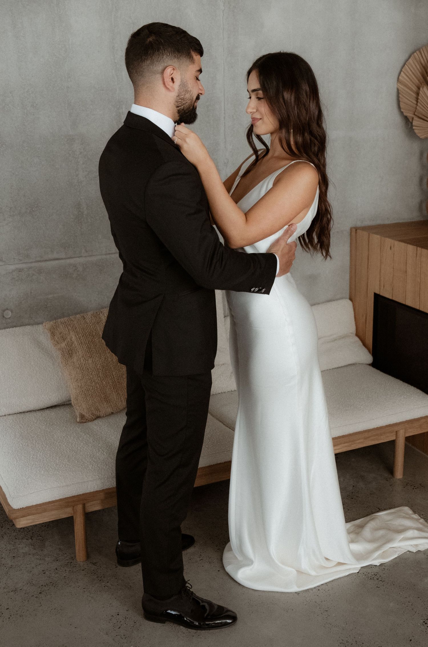 A couple in formal wedding attire embraces in an intimate moment.