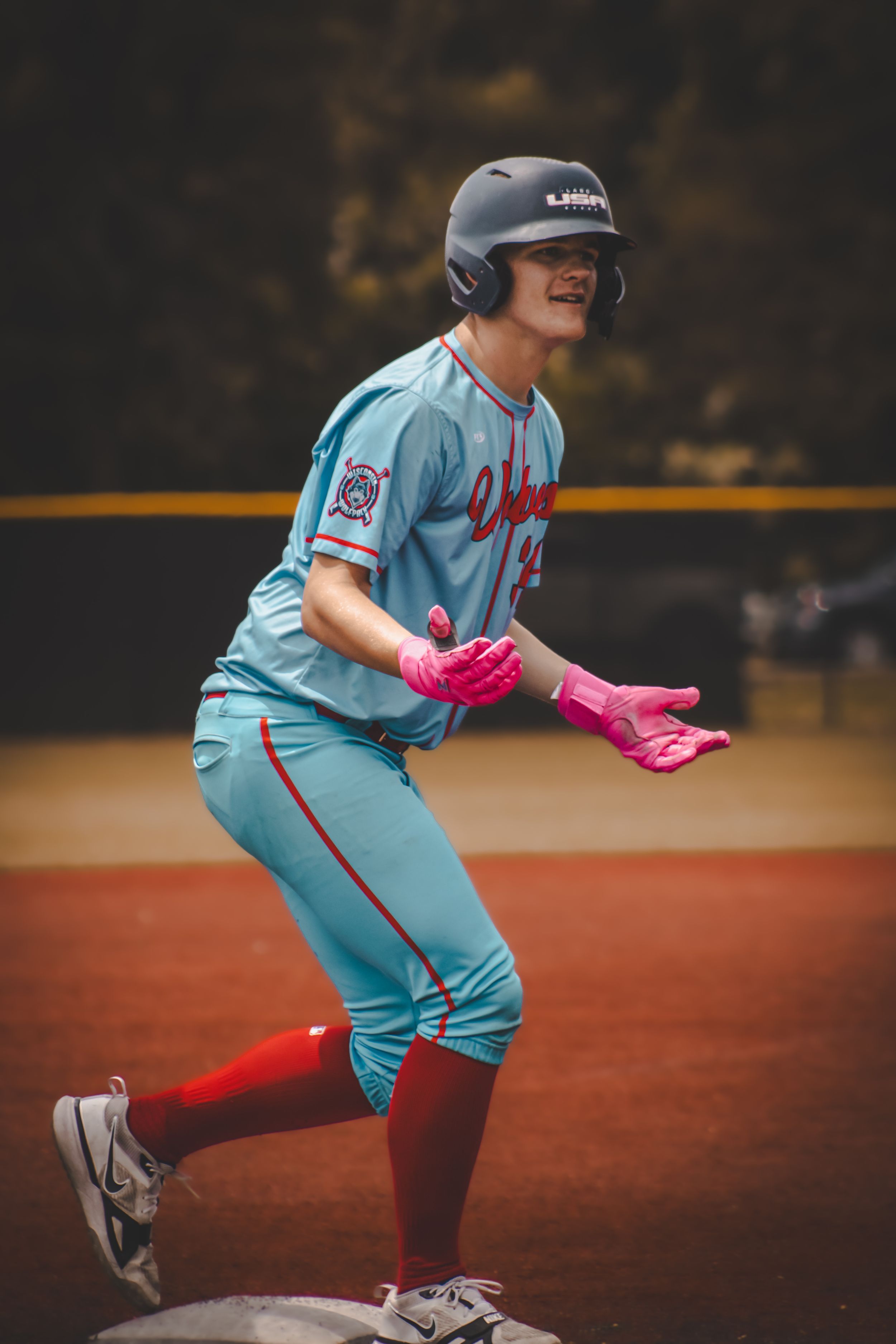 Baseball player on base with hands up awaiting an umpire's ruling on a call