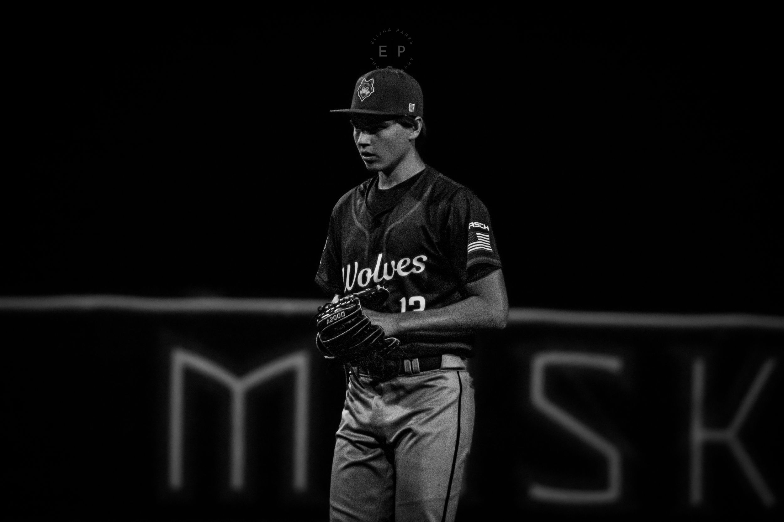 Baseball player in thought, standing on field with ball