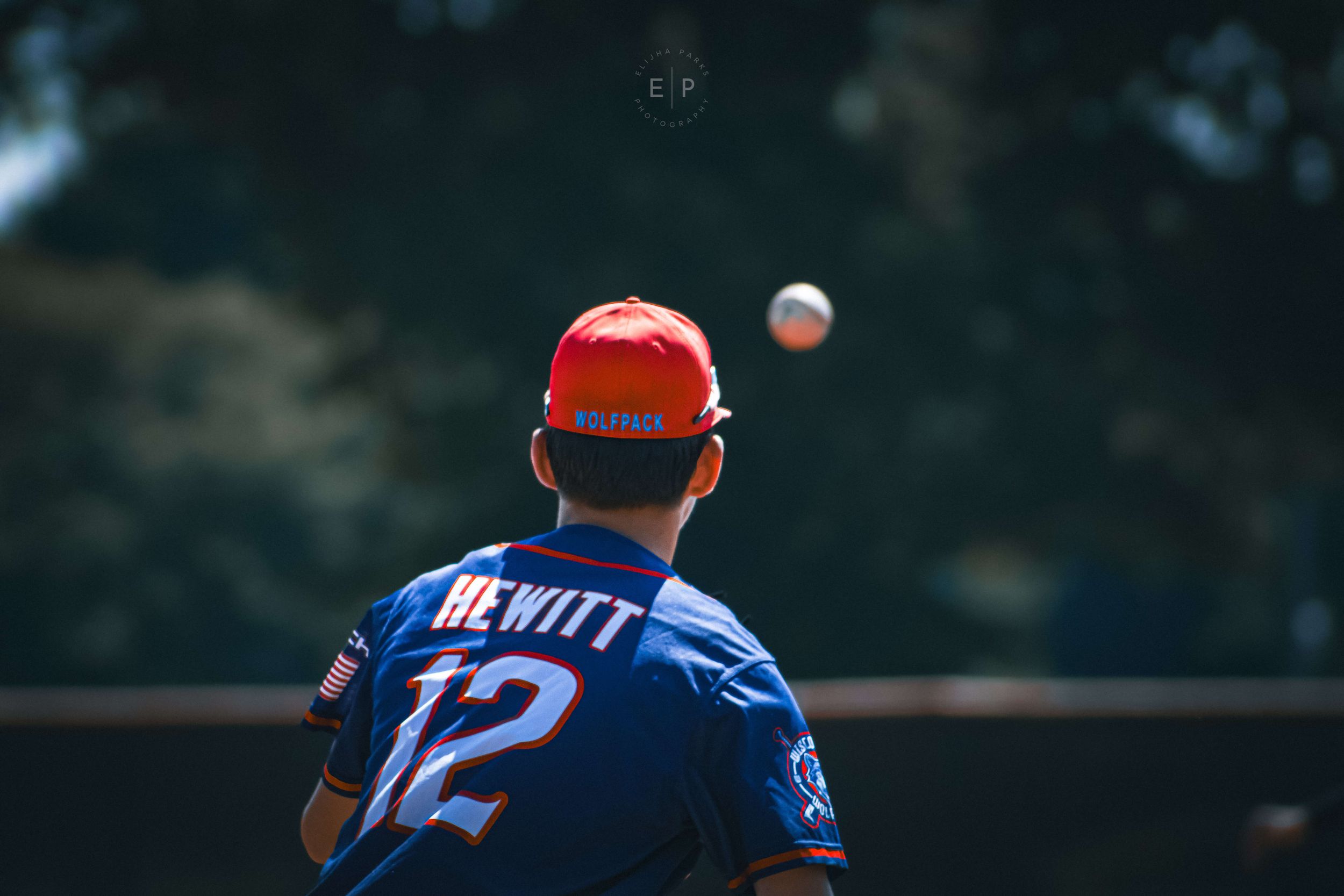 Baseball player tracking baseball with back to camera