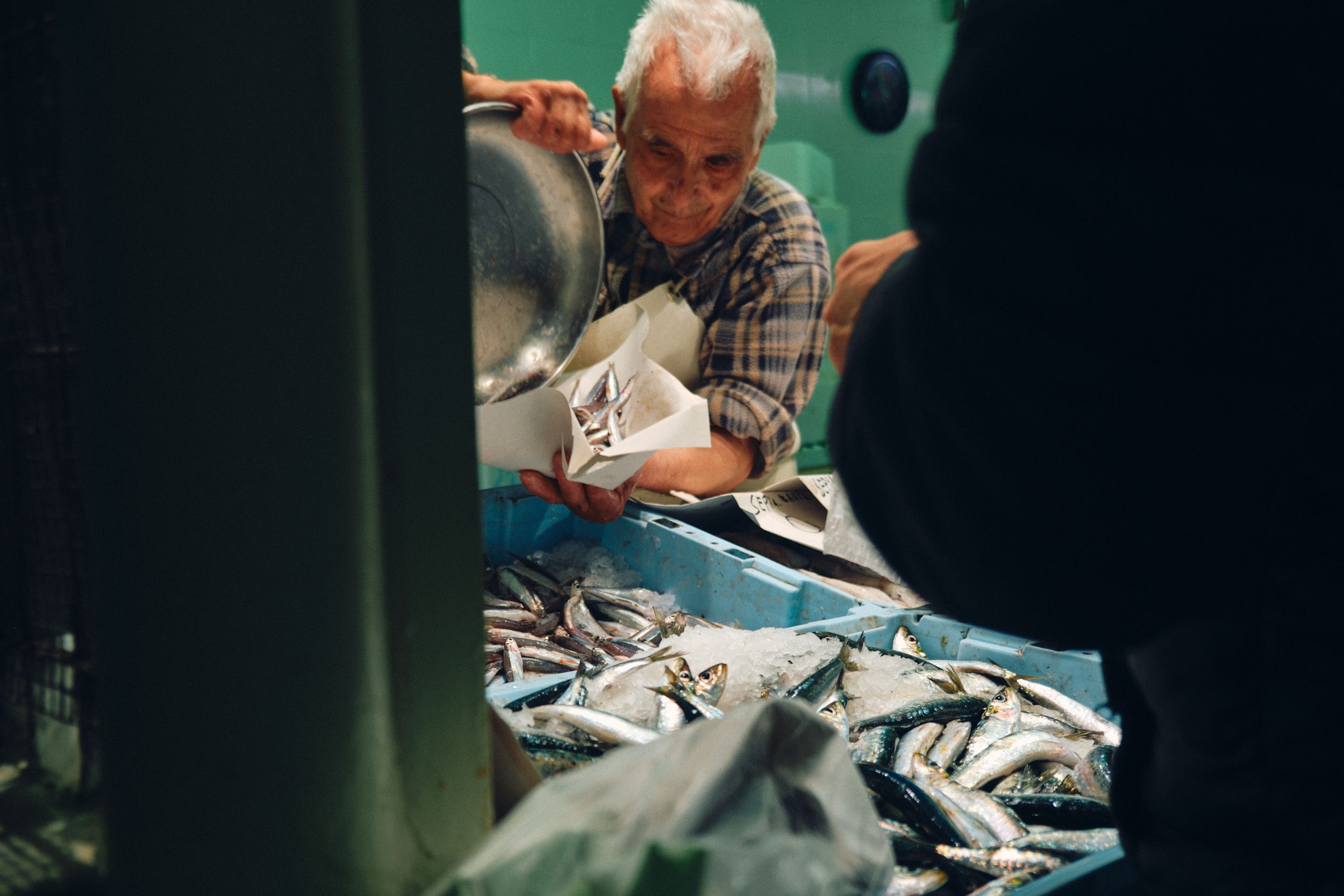 Fresh fish being prepared at seafood market counter.