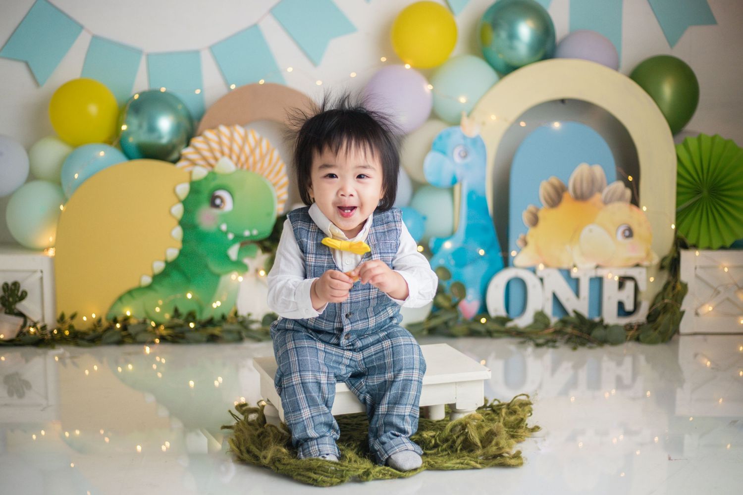 Dinosaur themed first birthday setup with colorful balloons and festive decorations.
